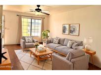 Inviting living room featuring neutral paint, plush seating, ceiling fan, and bright window at 7801 N 44Th Dr # 1180, Glendale, AZ 85301