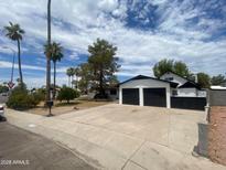 Charming home with a two-car garage, mature trees, and desert landscaping at 9053 N 53Rd Ave, Glendale, AZ 85302