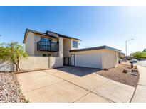 Two-story home with balcony, two car garage, and a private front yard with a block fence at 1521 W Jacinto Ave, Mesa, AZ 85202