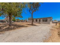 Well-maintained home featuring a clean gravel driveway, modern windows, and mature trees at 201 S 91St St, Mesa, AZ 85208