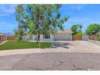 Charming single-story home featuring a well-maintained lawn, mature shade trees, and a two-car garage at 2607 E Mercer Ln, Phoenix, AZ 85028