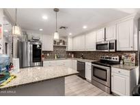 Bright kitchen featuring stainless steel appliances, granite countertops, and white cabinets at 2749 W San Juan Ave, Phoenix, AZ 85017
