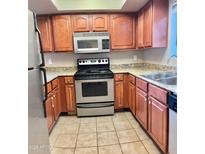 Well-lit kitchen featuring stainless steel appliances and ample countertop space at 3420 W Danbury Dr # C130, Phoenix, AZ 85053