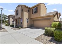Tan two-story home showcasing a two-car garage and a well-maintained front yard with decorative rock at 5421 W Burton Dr, Phoenix, AZ 85043