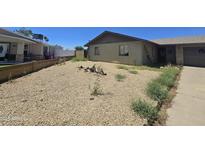 Modest single-story home featuring a low-maintenance gravel front yard at 14214 N 36Th Ave, Phoenix, AZ 85053