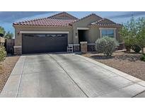 Charming single-story home with a well-maintained front yard, desert landscaping, and a two-car garage at 42087 W Manderas Ln, Maricopa, AZ 85138