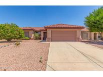 Charming single-story home featuring a terracotta-tiled roof and a desert-landscaped front yard at 15980 W Quail Creek Ln, Surprise, AZ 85374
