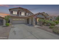 Charming two-story home features a covered porch, two car garage and desert landscaping at 16136 W Durango St, Goodyear, AZ 85338