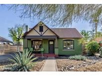Charming home with a rust-colored corrugated metal roof, green painted brick, and a well-manicured front yard at 1813 E Willetta St, Phoenix, AZ 85006