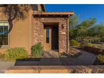 Inviting front entrance featuring a stone facade and well-maintained landscaping in a desert environment at 2062 W Roy Rogers Rd, Phoenix, AZ 85085