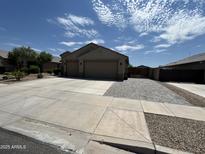Charming single-story home featuring a wide driveway and three-car garage at 22325 N 185Th Ave, Surprise, AZ 85387