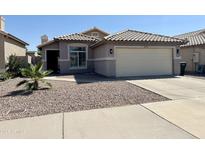 Charming single-story home with desert landscaping, tile roof, and attached two-car garage at 8673 W Palm Ln, Phoenix, AZ 85037