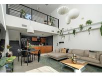 Open-concept living room featuring modern lighting, sleek black accents, and a cozy seating area with decorative plants at 1111 W University Dr # 1017, Tempe, AZ 85281