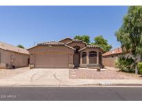 Charming single-Gathering home featuring a two-car garage, desert landscaping, and a welcoming facade at 1858 N 128Th Dr, Avondale, AZ 85392