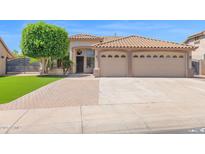 Charming single-story home featuring a tile roof, lush lawn, mature tree, and a two-car garage at 8354 W Marlette Ave, Glendale, AZ 85305