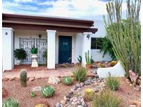 Inviting front entrance with desert landscaping and a charming teal door, enhancing curb appeal at 100 N Lazy Fox Rd # 8, Wickenburg, AZ 85390