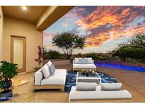 Inviting outdoor patio with comfortable seating, vibrant greenery, and a stunning sunset view creates a perfect relaxation space at 10119 E Winter Sun Dr, Scottsdale, AZ 85262