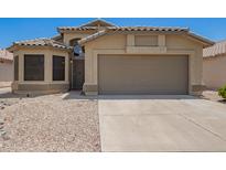 Inviting single-story home featuring a well-maintained yard and two-car garage, perfect for comfortable living at 15131 W Melissa Ln, Surprise, AZ 85374