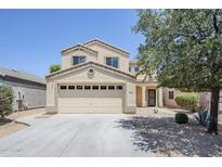 Inviting two-story home featuring a neutral color palette, desert landscaping, and attached two-car garage at 15205 N Honcho Ct, El Mirage, AZ 85335