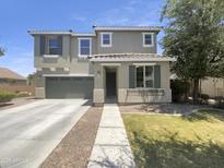 Charming two-story home featuring a well-maintained lawn, a two car garage, and a welcoming covered porch at 21262 E Cherrywood Dr, Queen Creek, AZ 85142