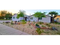 Charming home with a well-manicured front yard with desert landscaping and mature trees at 3128 E Desert Cove Ave, Phoenix, AZ 85028