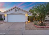 Charming single story home showcasing a two car garage, mature landscaping and a cozy desert front yard at 3550 E Edna Ave, Phoenix, AZ 85032