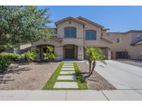 Charming two-story home with a desert landscape, enhanced by a modern walkway and inviting curb appeal at 44538 W Canyon Creek Dr, Maricopa, AZ 85139