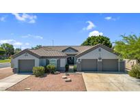 Charming single-story home featuring a tile roof, three-car garage, and inviting desert landscaping at 5529 E Holmes Ave, Mesa, AZ 85206