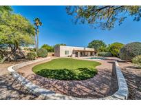 Beautiful backyard with a pool, green grass, and mature trees perfect for outdoor living and entertaining at 6615 E Phelps Rd, Scottsdale, AZ 85254