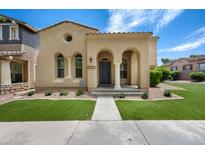 Charming single-story home with stucco facade, landscaped front yard, and welcoming arched entryway at 21017 W Edith Way, Buckeye, AZ 85396