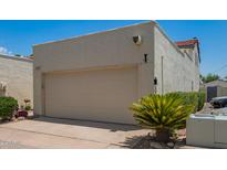 Exterior shot of attached garage with neutral paint, driveway, and desert landscaping on a sunny day at 2107 W Lane Ave, Phoenix, AZ 85021