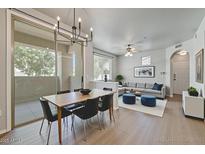 Bright living room featuring wood floors, a dining table, and a comfortable sofa at 29606 N Tatum N Blvd # 265, Cave Creek, AZ 85331
