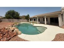 Backyard featuring a sparkling in-ground pool and well-maintained landscaping at 11006 S Indian Wells Dr, Goodyear, AZ 85338