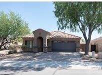 Charming single-story home with a desert landscape, paver driveway, and a two-car garage at 1381 E Prickly Pear Dr, Casa Grande, AZ 85122