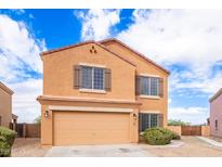 Two-story home featuring a two-car garage, landscaped yard, and inviting curb appeal at 18774 N Ibis Way, Maricopa, AZ 85138