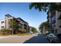 Modern townhomes with well-manicured landscaping lining a quiet street under a clear blue sky at 19360 N 73Rd St # 1058, Scottsdale, AZ 85255