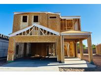Framed two-story home under construction with a garage and covered entry on a clear day at 4977 E Umber Rd, San Tan Valley, AZ 85143