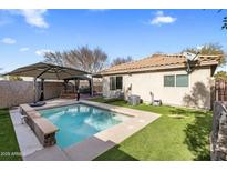 Inviting backyard pool features a gazebo and artificial turf creating a low-maintenance outdoor living space at 601 E Banelli Pl, Chandler, AZ 85286