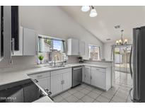 Bright kitchen featuring stainless steel appliances, white cabinetry, and natural light at 8013 W Vermont Ave, Glendale, AZ 85303