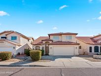 Inviting two-story home featuring a red tile roof, well-manicured landscaping, and a welcoming facade at 12547 W Edgemont Ave, Avondale, AZ 85392