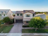 Stunning two-story home features a brick driveway, neutral stucco, manicured landscaping, and a tile roof at 3556 E Austin Dr, Gilbert, AZ 85296