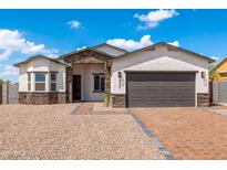 Charming single-story home featuring a stone facade, brick driveway, and two-car garage at 8226 W Swansea Dr, Arizona City, AZ 85123