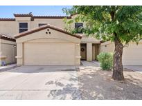 Inviting home featuring a two-car garage, neutral stucco, and well-manicured landscaping with a mature tree at 125 S 56Th St # 27, Mesa, AZ 85206