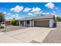 Charming single-story home with a two-car garage, low-maintenance landscaping, and a long concrete driveway at 14010 N 42Nd Dr, Phoenix, AZ 85053