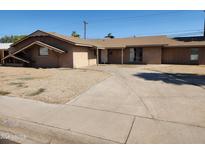 Single story home showcasing its desert landscaping, a long driveway and front facade at 6017 W Colter St, Glendale, AZ 85301