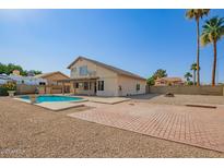 Spacious backyard featuring a refreshing pool, patio, and low-maintenance desert landscaping at 7709 W Hearn Rd, Peoria, AZ 85381