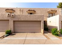 Beige townhome exterior featuring a two-car garage, stucco walls, and classic tile roof at 8540 N Central Ave # 6, Phoenix, AZ 85020