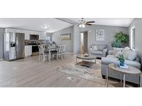 Open floorplan showcasing a living room with gray walls, modern furnishings, and seamlessly connected kitchen and dining areas at 320 E Mckellips Rd # 34, Mesa, AZ 85201