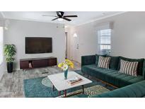 Inviting living room featuring a plush green sectional sofa, modern ceiling fan, and large television at 320 E Mckellips Rd # 4, Mesa, AZ 85201