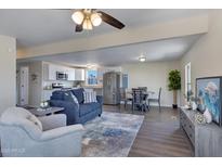 Open-concept living room with a modern kitchen, dining table, and a comfortable seating area with plush furniture at 320 E Mckellips Rd # 44, Mesa, AZ 85201